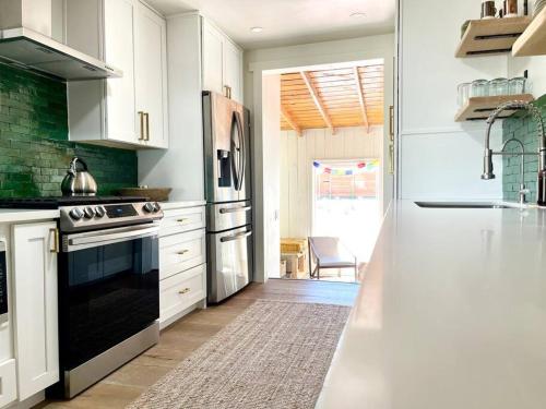 a kitchen with white cabinets and a black oven at Blue Sunday, Desert House w/ hot tub -Joshua Tree in Joshua Tree