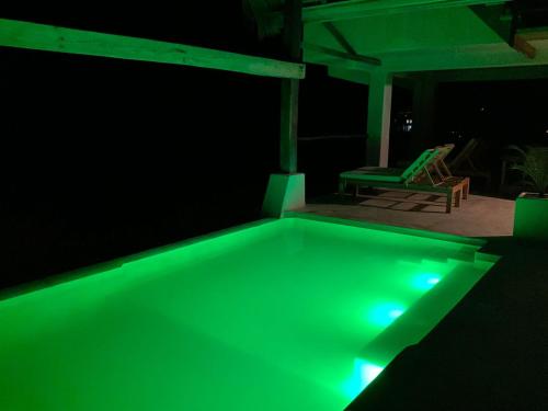 a green lighted swimming pool in a dark room at Casa Gitana in Chamuscadero