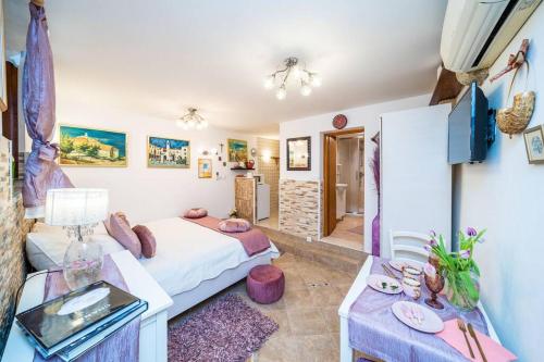ein Schlafzimmer mit einem Bett und einem Tisch in einem Zimmer in der Unterkunft Plaza Green in the centre in Dubrovnik