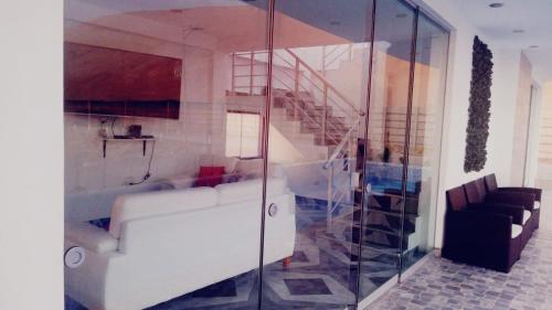 ein Wohnzimmer mit einer weißen Couch und einer Treppe in der Unterkunft YAKYS TOPARA in Jaguay