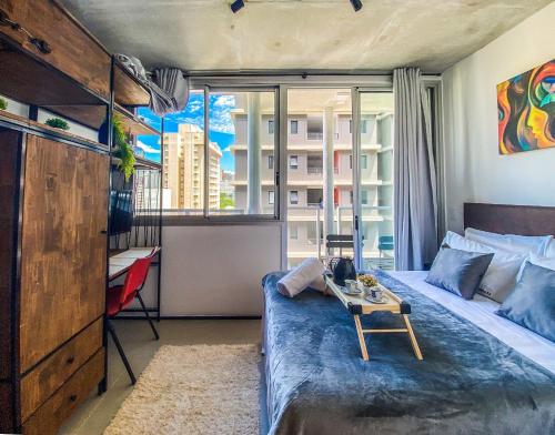 um pequeno quarto com uma cama e uma janela em Glow Frei Caneca - Vivare em São Paulo