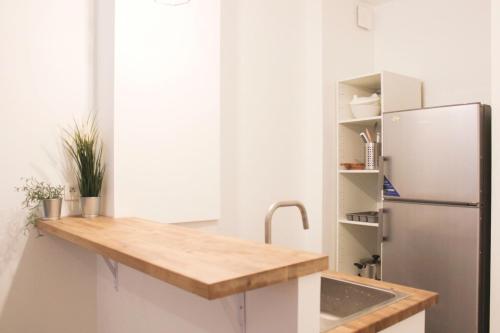 une cuisine avec un évier et un réfrigérateur dans l'établissement Nice 30 m near Canal St Martin, à Paris