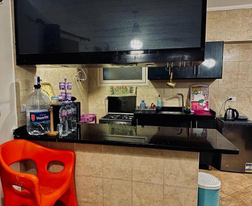 a kitchen with a red chair and a counter top at Telal elsokhna families in Ain Sokhna
