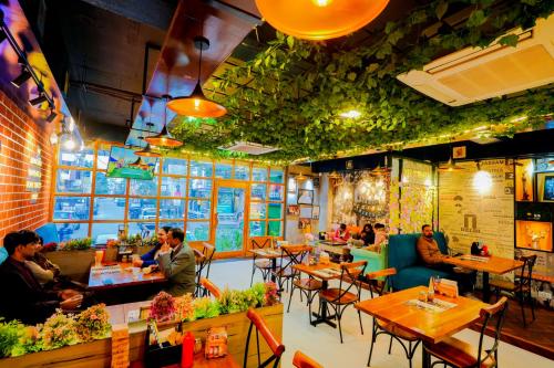 a restaurant with tables and people sitting at tables at Hotel Pinkcity Prime & Chicago View Cafe in Jaipur