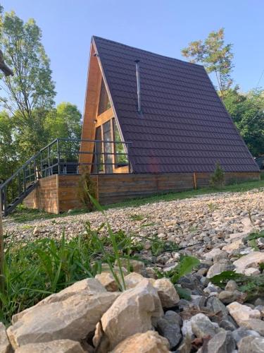 a house with a roof on top of a pile of rocks at Casutele din Poienita in Comarnic