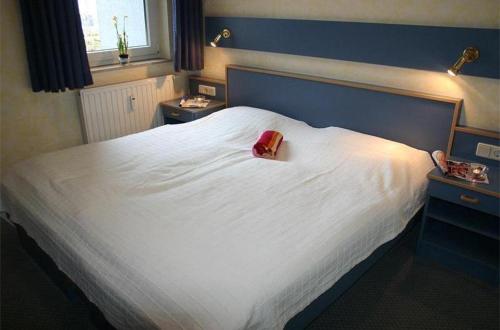 キュールングスボルンにあるYachthafenresidenz-Wohnung-5204-813の白い大型ベッド(赤い財布付)