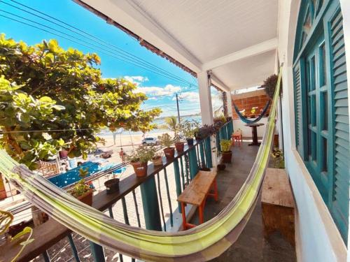 een balkon met een hangmat en uitzicht op de oceaan bij Maré Mansa Pousada e Hostel in Itacaré