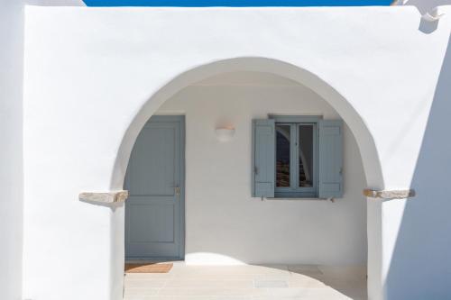 an archway with a blue door on a white wall at Villa Levantes - quiet location with private pool in Márpissa