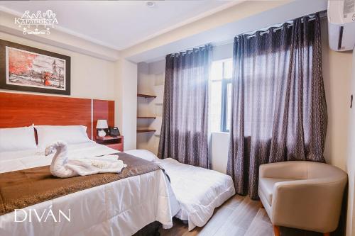 Hotel Kapadokya في هانوكو: غرفة نوم بجعة على السرير وكرسي