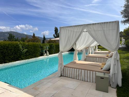 a bed with a canopy next to a swimming pool at Carmo's Boutique Hotel - Small Luxury Hotels of the World in Ponte de Lima