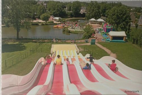 a group of children sitting on a slide at an amusement park at Cottage chaleureux à 25 mn de la côte de granit rose in Bégard