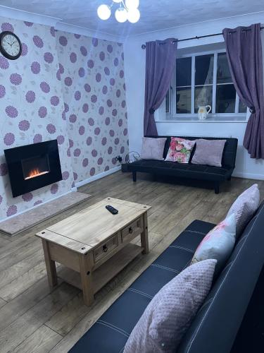 a living room with a couch and a coffee table at Princess Wigan House in Wigan