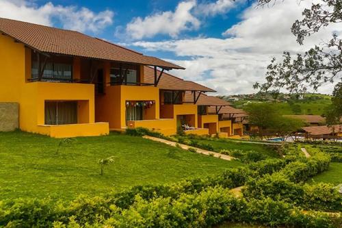 uma casa amarela com um relvado verde em frente em Winterville Gravatá Lazer e descanso! em Gravatá