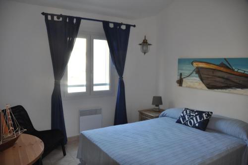 a bedroom with a bed and a window at Arc en ciel, vue mer et piscine dans résidence in Saint Pierre La Mer