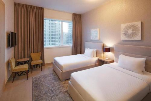 a hotel room with two beds and a window at Marina Two Bedroom With Balcony - KV Hotels in Dubai