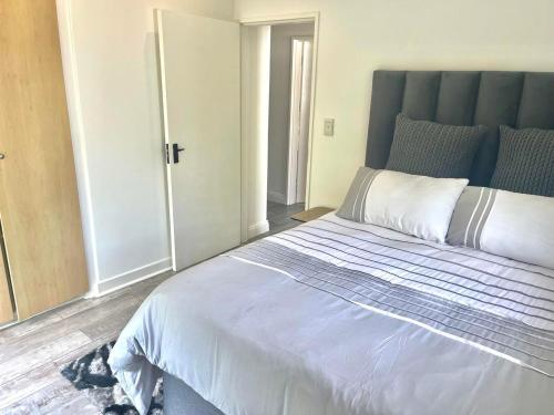 1 dormitorio con 1 cama grande y cabecero azul en KRJSA Townhouse -Bryanston, en Johannesburgo