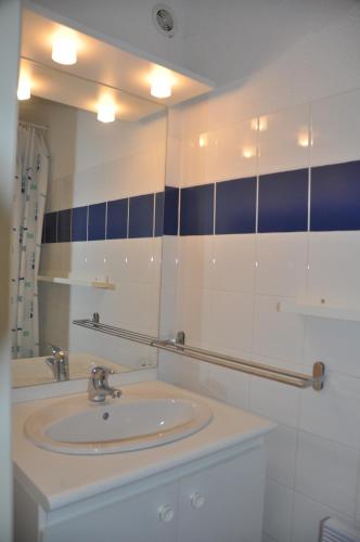 a bathroom with a sink and a mirror at Arc en ciel, vue mer et piscine dans résidence in Saint Pierre La Mer