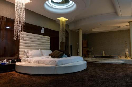 1 dormitorio con 1 cama blanca grande en una habitación en فيلا كامله للايجار اليومي, en Medina