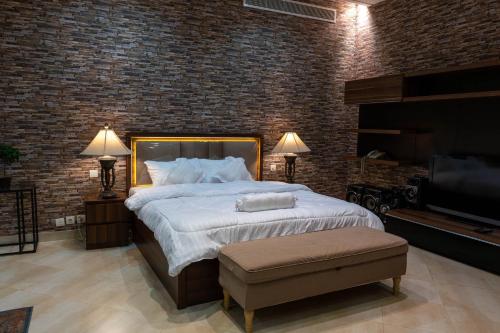 a bedroom with a large bed and a brick wall at فيلا كامله للايجار اليومي in Al Madinah