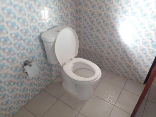 a bathroom with a toilet with a roll of toilet paper at Lovely 1-Bed duplex house in Abidjan