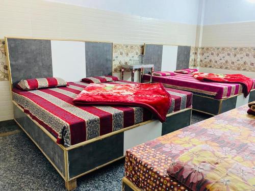 a group of three beds in a room at Hari Ganga Near By Bus And Railway Station in Haridwār