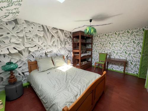 - une chambre avec un lit orné d'une fresque murale dans l'établissement La Maison d'Andrée, à Pluvet
