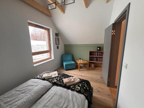 um quarto com uma cama, uma janela e uma cadeira em Villa Monte Apartament z ogrodem em Kudowa-Zdrój