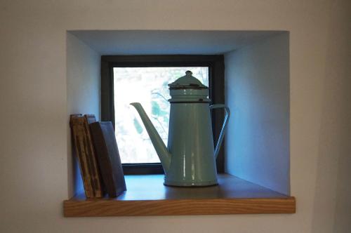 a green tea kettle sitting on a shelf next to a window at Superbe Maison en baie du Mont St Michel in Vains