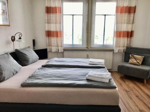 ein Schlafzimmer mit einem großen Bett und einem Stuhl in der Unterkunft Thüringer Hof in Heringen