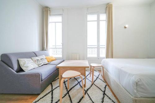 - une chambre avec un canapé, un lit et une table dans l'établissement Studio Buttes-Chaumont - Hautpoul - IV, à Paris