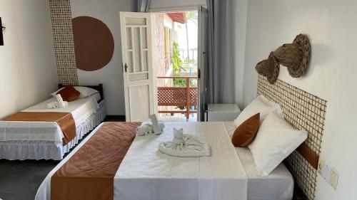 a bedroom with two beds with towels on them at Hotel Brisa dos Abrolhos in Alcobaça