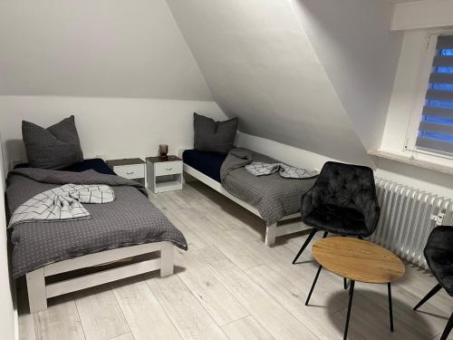 Un dormitorio con 2 camas y una silla. en Ferienwohnung, Monteurwohnung, Unterkunft in Warstein NRW, Deutschland en Warstein