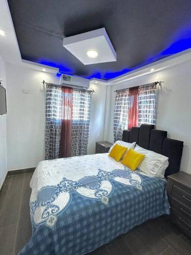 Un dormitorio con una cama con luces azules. en JC Caribe Aparta Hotel #1 en La Caleta