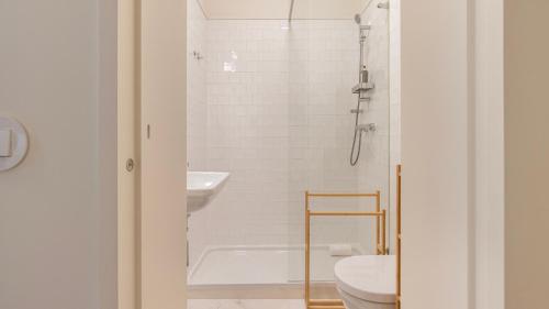 uma casa de banho com um chuveiro, um WC e um lavatório. em 2BDR Alcântara Nest by LovelyStay em Lisboa