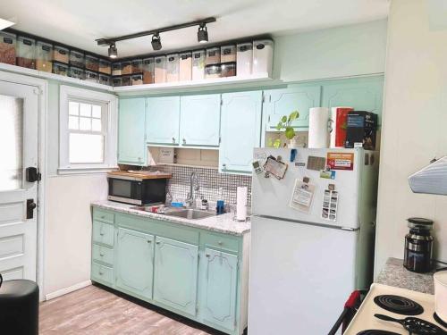 a kitchen with blue cabinets and a white refrigerator at 10 min Downtown-3 min Irvington in Indianapolis