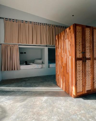 sypialnia z łóżkiem i dużymi drewnianymi drzwiami w obiekcie Tukasa - Surfhouse Popoyo w mieście Popoyo