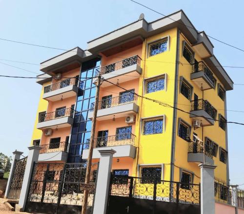 a yellow building with black balconies at RESIDENCE E.P in Emana