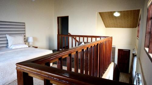 a bedroom with a bed and a wooden stair railing at Cliffhaven Beach Resort Hotel in Accra