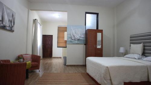 une chambre d'hôtel avec un lit et une chaise dans l'établissement Cliffhaven Beach Resort Hotel, à Accra