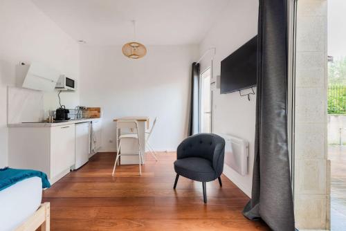 Il comprend un salon avec une chaise et une cuisine. dans l'établissement Studio au calme au Bouscat - le Gambetta, à Le Bouscat