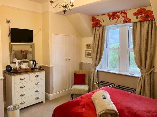 a bedroom with a bed and a window and a dresser at Maple Bank Country Guest House in Keswick