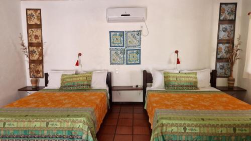Cette chambre comprend 2 lits et une fenêtre. dans l'établissement Pousada Casa da Edinha, à Île de Boipeba