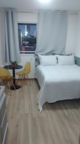 a bedroom with a bed and a table and chairs at Smart Studio in Salvador