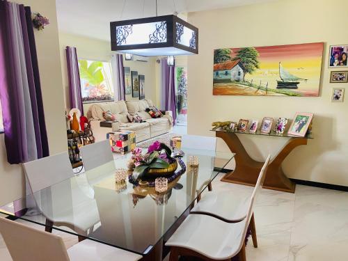 a living room with a glass table and chairs at Villa Paradise in Brazil - Praia de Guaratiba Prado-BA in Prado