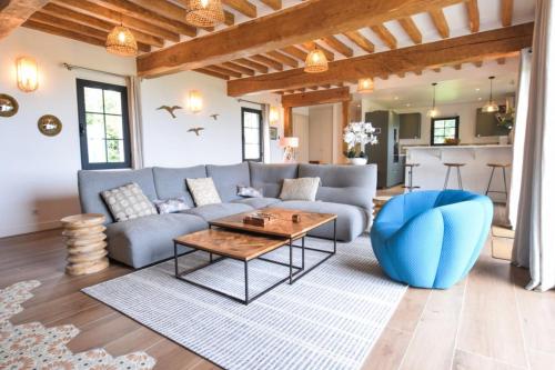 - un salon avec un canapé bleu et une table dans l'établissement Villa Biloba - sea view and beach access 10 People, à Cricquebœuf
