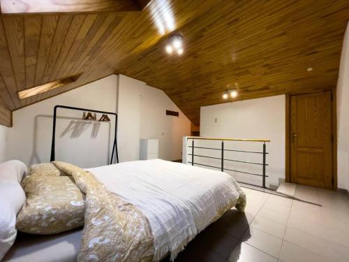 1 dormitorio con 1 cama grande y techo de madera en Comfortable house G00gle-SHAPE- Chièvres Air Base, en Saint-Ghislain