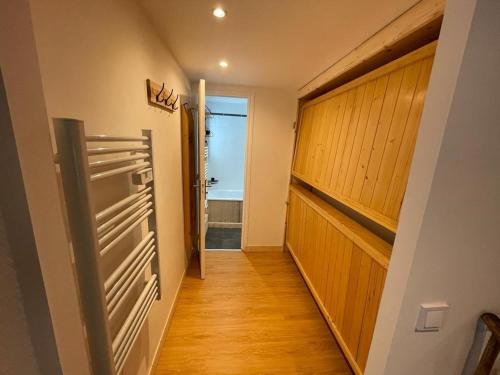 Elle comprend un couloir avec un réfrigérateur et une porte menant à une salle de bains. dans l'établissement Studio rénové avec balcon, au pied des pistes, WiFi et proche commodités - FR-1-502-552, à Tignes