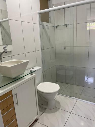 a bathroom with a toilet and a sink and a shower at Casa praia do santinho in Florianópolis