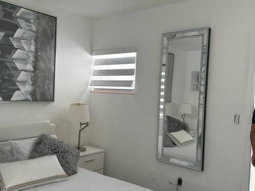 a white bedroom with a mirror and a bed at Villa Clara SUITE - Little Havana in Miami