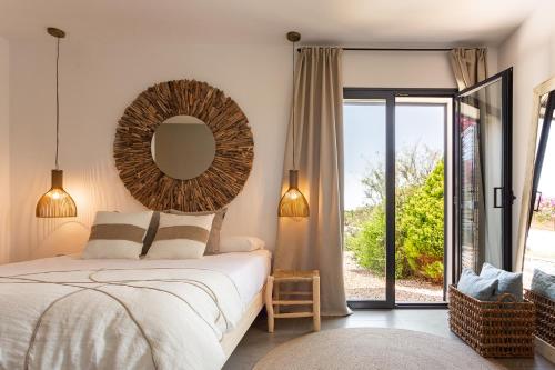 een slaapkamer met een bed met een spiegel aan de muur bij Somnis in La Mola